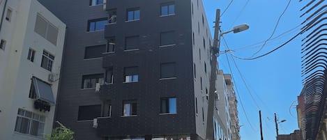 A modern multi-story building with a dark facade and multiple windows.