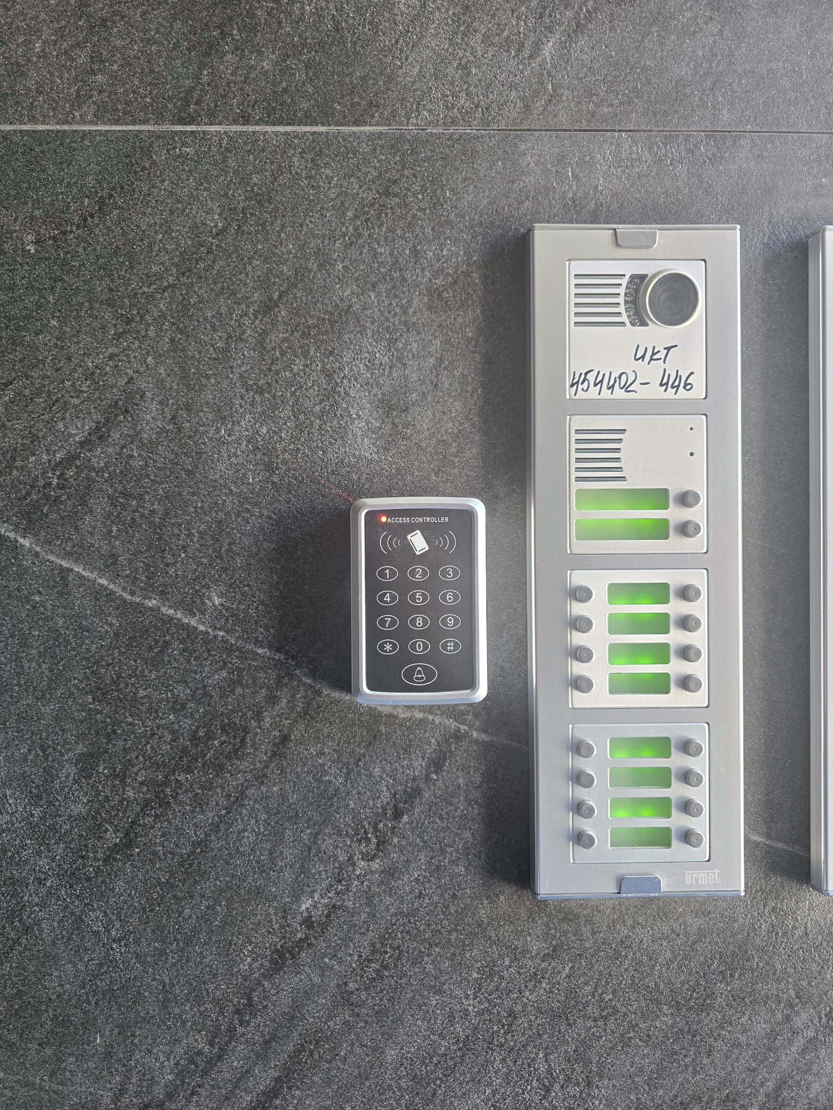 A keypad and a control panel with multiple buttons and indicators, likely for room access or security systems.