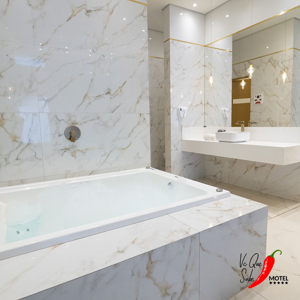 Ein modernes Badezimmer mit einer Marmorbadewanne, einem Waschtisch und einem großen Spiegel.