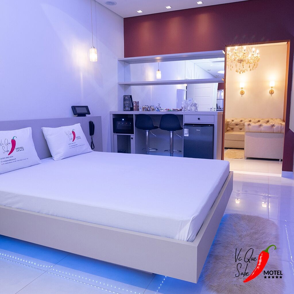 Una habitación de hotel moderna con una cama grande, una kitchenette y un comedor.