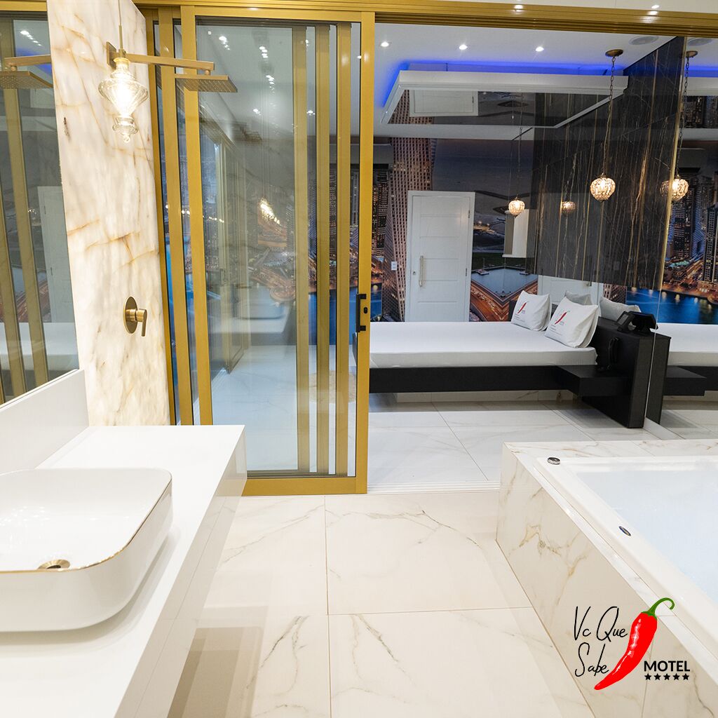 A modern bathroom with a large bathtub, a separate shower area, and a glass-enclosed vanity.
