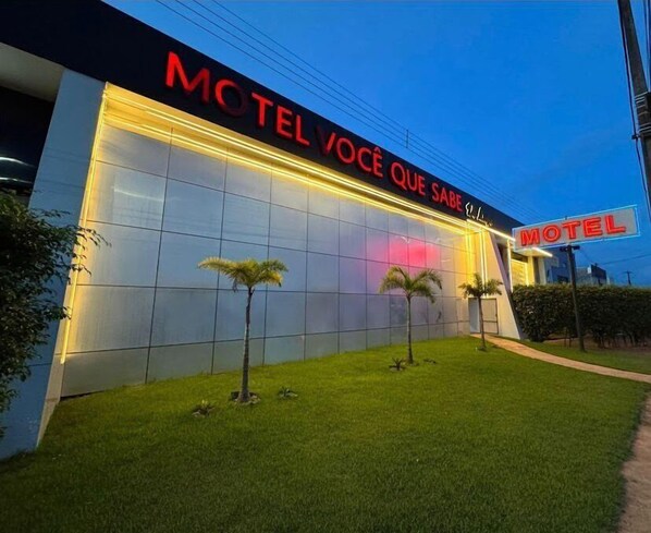 Un motel moderno con un amplio frente de vidrio y un letrero de neón.