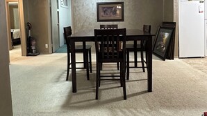 Un comedor con una mesa y sillas, una lámpara de techo y un cuadro en la pared.