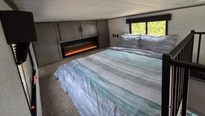 Una camera da letto con un letto, un camino e una finestra.