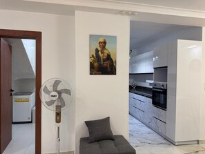 Eine moderne Küche mit weißen Schränken, einem eingebauten Backofen und einer Marmor-Spritzschutzwand.