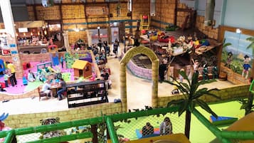 An indoor play area with various play structures and a climbing wall.