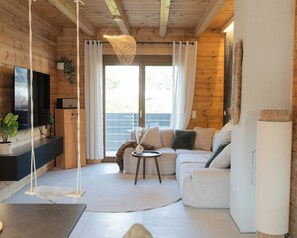 A cozy living room with a sofa, a small table, and a television.