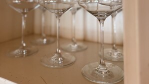 Una estantería con varios vasos de vino.