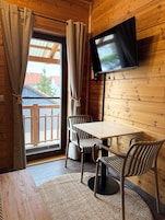 Quarto triplo conforto, várias camas, sacada | Área de estar | TV