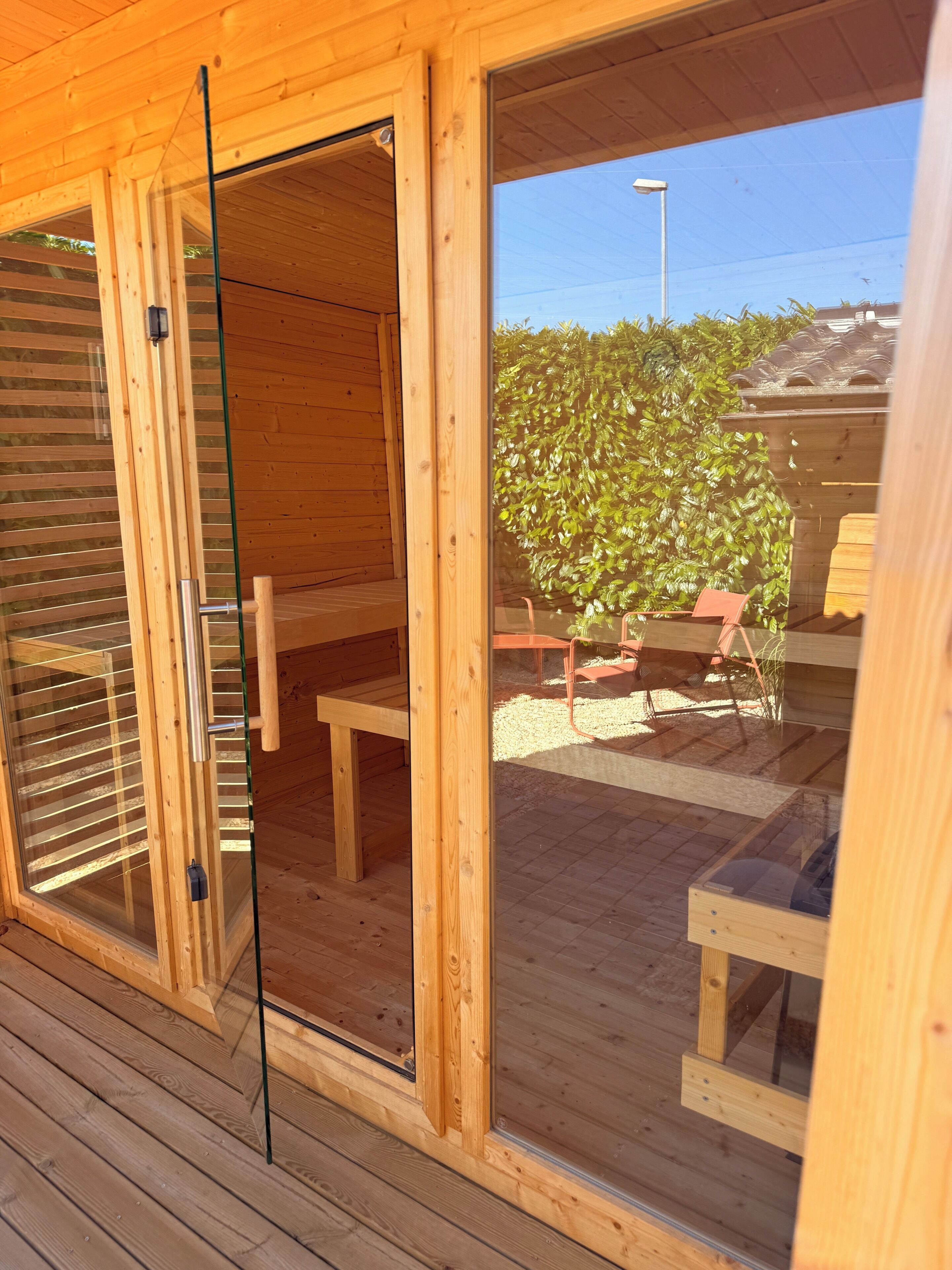 A wooden cabin with a sliding glass door leading to an outdoor seating area.