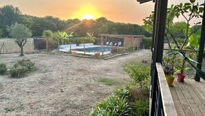 A backyard with a pool, a wooden deck, and a view of the sunset. - Modern haven of peace with panoramic views (Saint-Caprais-de-Bordeaux)