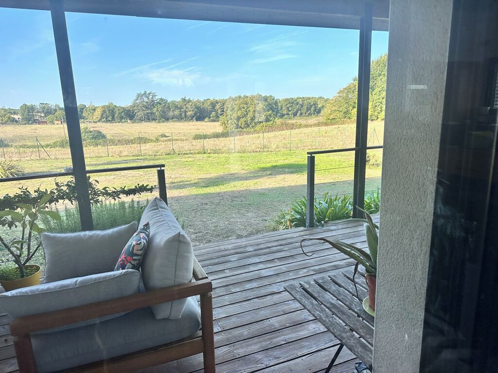 Eine Holzterrasse mit einer Couch und einem Blumentopf.