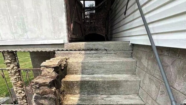 Eine Betontreppe mit Steinstufen, die zu einer Tür führen.