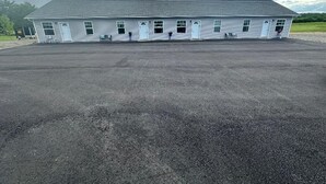 Un bâtiment d’un seul étage, doté d’un toit plat et d’un grand parking à l’avant.