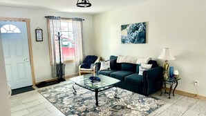Un salon avec un canapé, une table basse et une lampe.