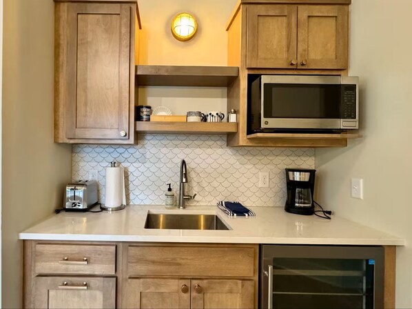 Fridge, microwave, coffee/tea maker, cookware/dishes/utensils