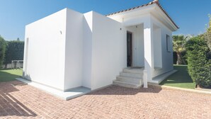 A modern white building with a tiled roof, a small porch, and a brick driveway. - Ayia Napa Satin Villa SVI1 by Interhome (Ayia Napa)