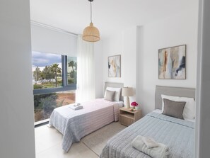 A modern bedroom with two beds, a large window, and artwork on the walls. - Protaras Aqua Pearl Villa AQ01 by Interhome (Protaras)
