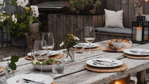 A rustic outdoor dining setup with a wooden table, string lights, and a cozy seating area. - Viktorianische Villa mit Strandblick by Interhome (Dundee)