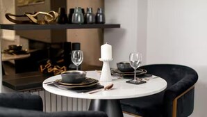 A dining table with a white candle centerpiece, two wine glasses, and black plates. - Near Transport - Hot tub - Fireplace - Sleeps 2 (Edinburgh)