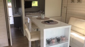A compact living space with a kitchenette, a dining area, and a sofa. - Hausboot KHT 2 Lacet mit Elektrokamin im Salon, 1 Schlafraum, Küche, Duschbad m by Interhome (Wilhelmshaven)