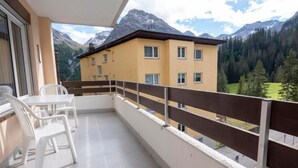 A balcony with a table and chairs, overlooking a mountain landscape. - Arosa - alles komplett by Interhome (Arosa)