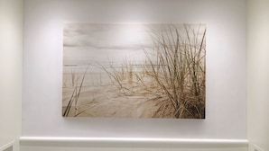 Uma parede com uma pintura de uma cena de praia.