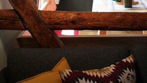 Um interior acolhedor com uma escada de madeira, uma sala de jantar com mesa e cadeiras, e uma cozinha com eletrodomésticos modernos.