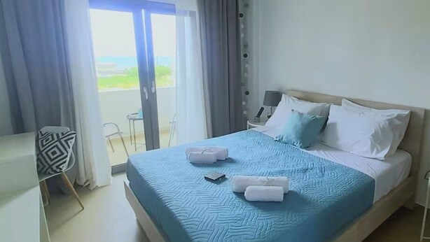 Ein Hotelzimmer mit Bett, Schreibtisch und Blick ins Freie.