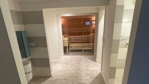 A modern room with a stone floor, a wooden bench, and a small table. There is a blue cabinet and a white door in the background. - für 5 Personen  + 1 Kind ca. 180 m² in Nieblum, Norddeutschland (Nordseekü by Interhome (Goting)
