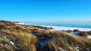 A beach with sand and grass in the foreground, and a clear blue sky. - für 5 Personen  + 1 Kind ca. 180 m² in Nieblum, Norddeutschland (Nordseekü by Interhome (Goting)