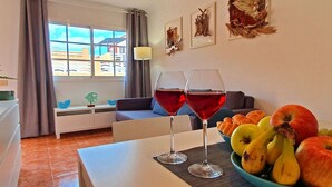 A dining area with a table set for two, two wine glasses, and a bowl of fruit. - Casa Cristof by Interhome (Costa Calma)