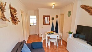 A compact living space with a sofa, dining table, chairs, and a TV. - Casa Cristof by Interhome (Costa Calma)