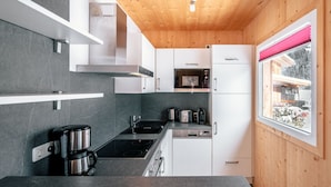 Une cuisine moderne avec des plans de travail gris, des appareils en acier inoxydable et des murs en bois.
