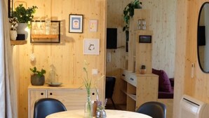 Un ambiente accogliente in legno, con un tavolo rotondo, sedie nere e una lampada a sospensione.