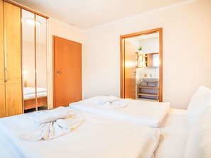 A hotel room with a bed, a wooden wardrobe, a bathroom with a sink and mirror. - Apartment 3 by Interhome (Bansin)
