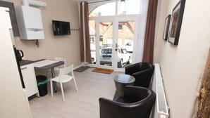 A compact living space with a kitchenette, a dining area, and a seating area with a view of the street. - Wohnung in Bad Segeberg mit Terrasse by Interhome (Bad Segeberg)