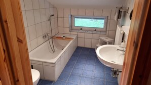 Un bagno moderno con una vasca, un water e un lavandino.