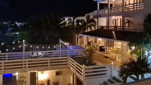 Ein zweistöckiges Gebäude mit Balkon und Außenbereich, umgeben von Palmen.