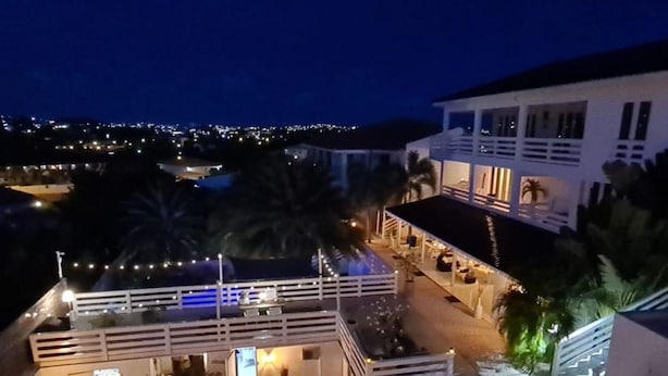 Ein Strandgrundstück mit Pool, Sitzgelegenheiten im Freien und einer überdachten Terrasse.