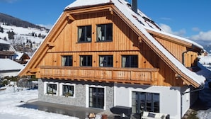 A wooden chalet with a balcony, large windows, and a stone foundation. - Appartement Lee by Interhome (Mauterndorf)