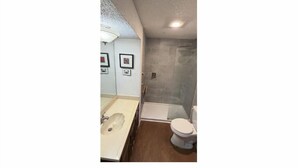 Un baño con ducha, inodoro y lavabo.