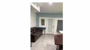 Una sala de estar con un sofá, una mesa de centro y un mueble para televisión.