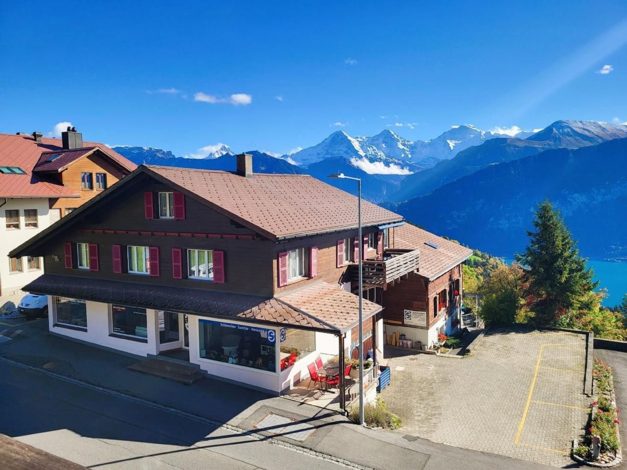 Un hôtel avec vue sur la montagne, un espace extérieur aménagé et couvert, et un parking.