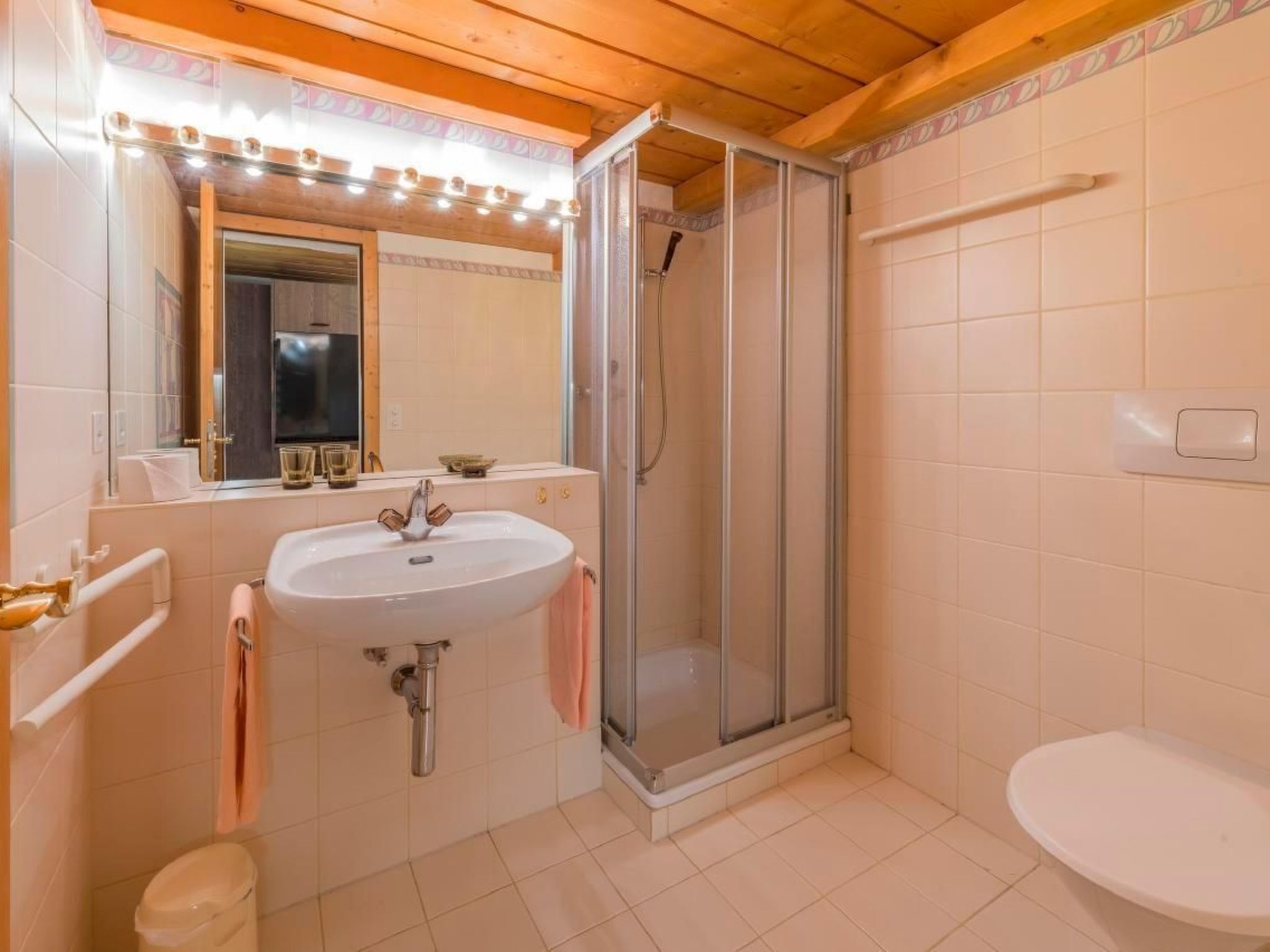 Ein Badezimmer mit Waschbecken, Spiegel, Dusche und Toilette.