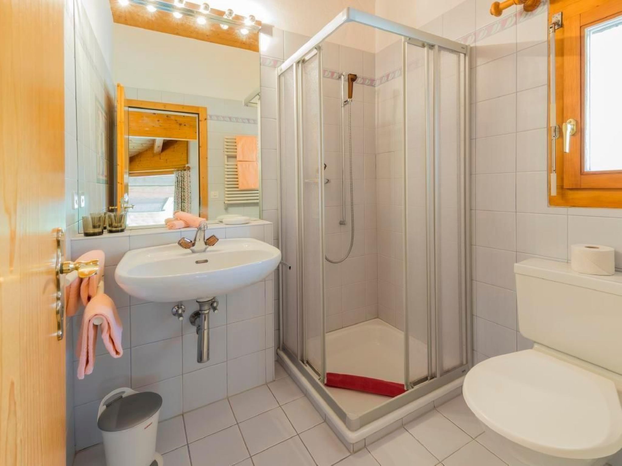 A bathroom with a shower, sink, and toilet.