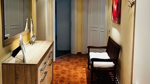 A narrow hallway with a wooden vanity, a chair, and a bed. - Haus Goodewind by Interhome (Ahlbeck)