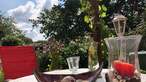 A table with a decorative bowl containing seashells and a glass pitcher.