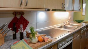 A modern kitchen with stainless steel appliances, wooden cabinets, and a granite countertop.