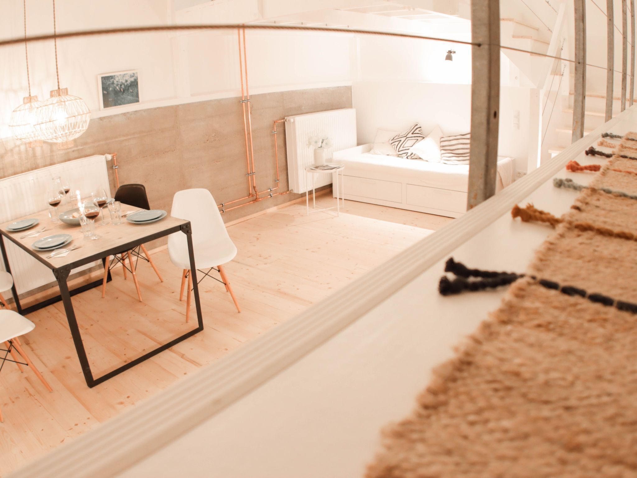 A modern hotel room with a dining area, a sofa, and a view of the city.
